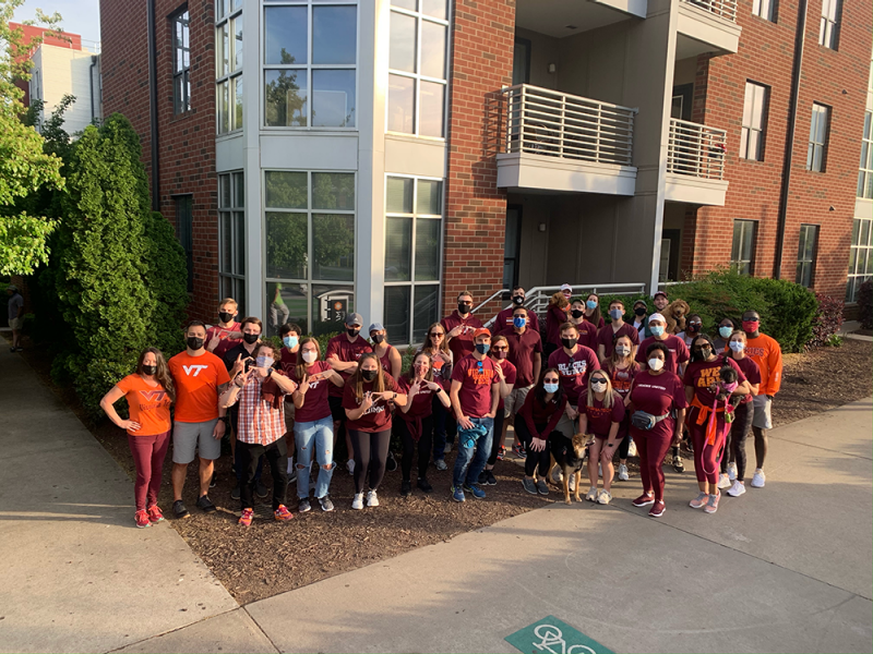 a group of Hokies in athletic gear in front of a building 