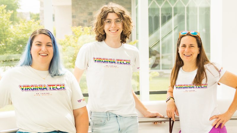 Three Hokies wearing rainbow Virginia Tech shirts