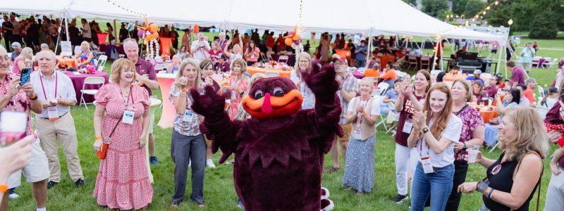 Alumni dance with the HokieBird at the party on the drillfield