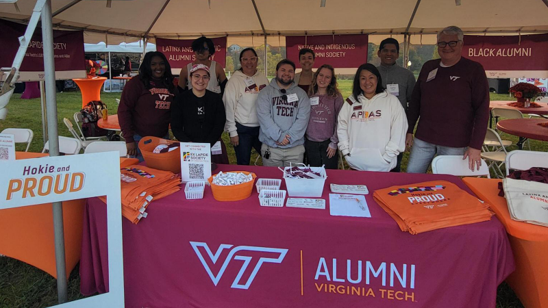 Alumni pose for a picture at the Inclusive alum tent at Homecoming